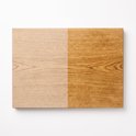 Houten snijplank, links onbehandeld, rechts geolied, met zichtbare houtnerf.