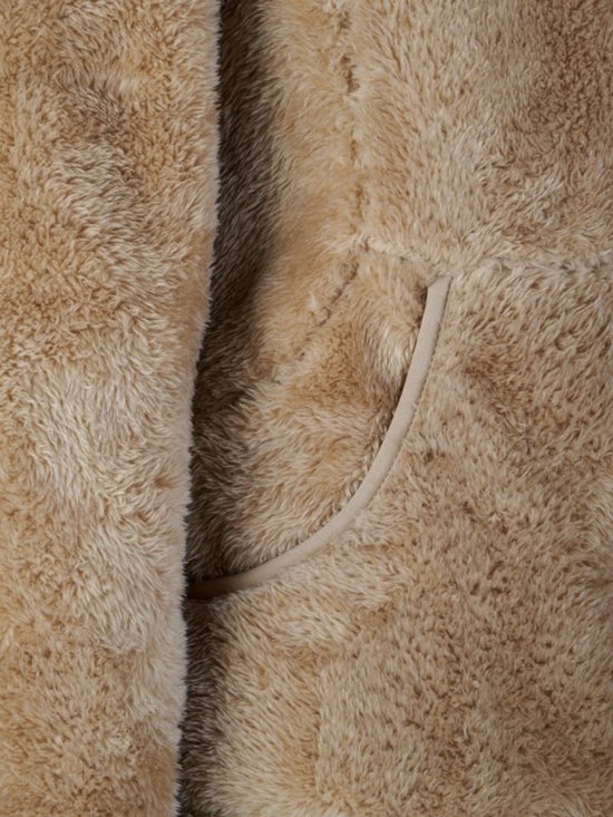 Close-up van een camelkleurige fleecevest met een open zak en beige bies.