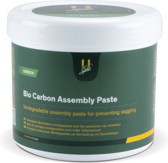 Witte pot met deksel, met een groen label met "Bio Carbon Assembly Paste" en "CARBON". De pot staat op een witte achtergrond.