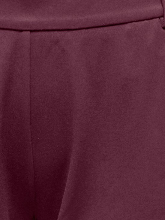 Close-up van de stof van een bordeauxrode broek.