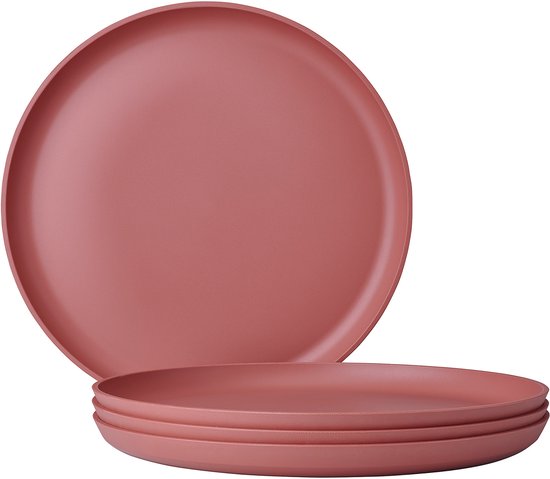 Une pile de quatre assiettes plates, rose ancien, sur fond blanc.