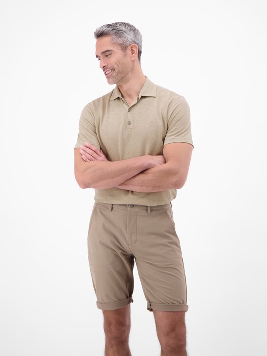 Man met grijzend haar draagt een beige LERROS poloshirt en een beige korte broek, armen gekruist.