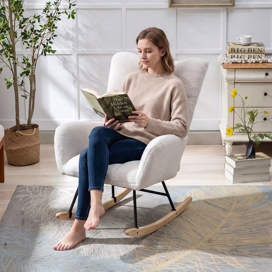 Vrouw leest boek in een witte teddy schommelstoel met zwarte metalen poten.