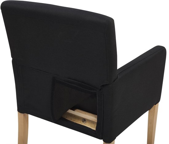 Détail de l'arrière d'une chaise de salle à manger noire montrant une poche de rangement sous l'assise.