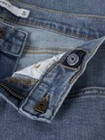 Sluiting en tailleband van een lichtblauwe jeans met knoop en ritssluiting.