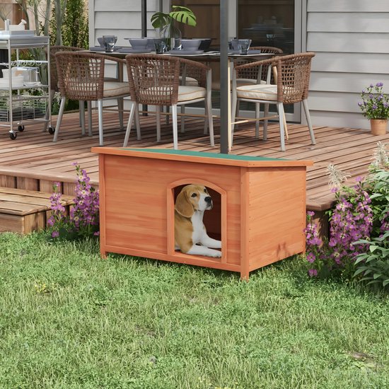 Houten hondenhok met groen dak in een grasrijke tuin, met een beagler pup erin.