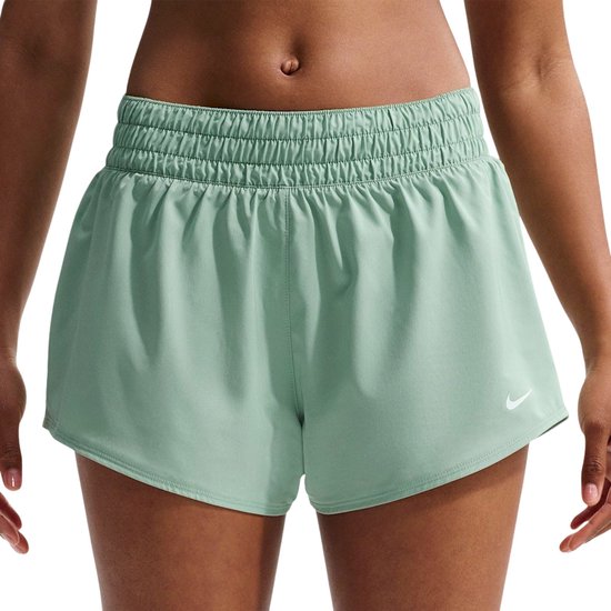 Close-up van mintgroene Nike shorts met zwarte ingebouwde legging en witte Nike logo's.