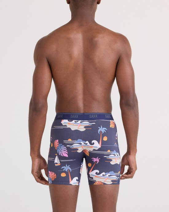 Achterkant van een man die een navy boxershort draagt met print van zeilboten, palmbomen, golven en zonsondergangen.