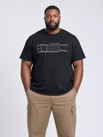 Man met een zwarte T-shirt met schematische tekening van een vrachtwagen, en beige cargo broek.