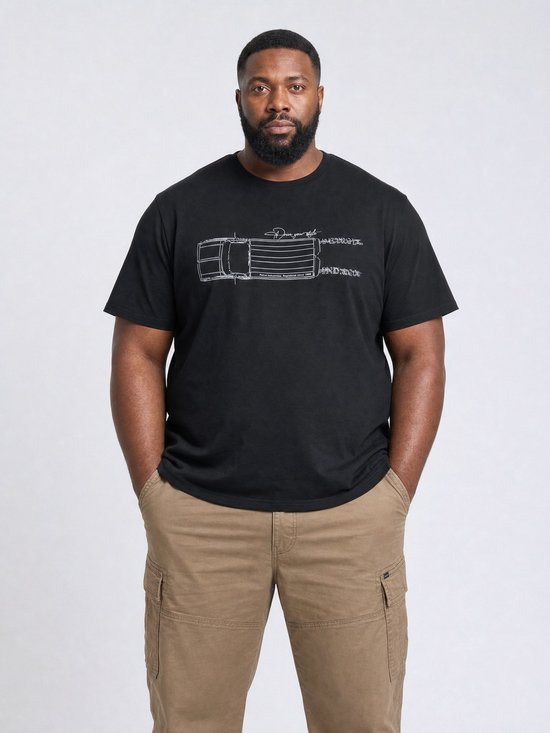 Man met een zwarte T-shirt met schematische tekening van een vrachtwagen, en beige cargo broek.