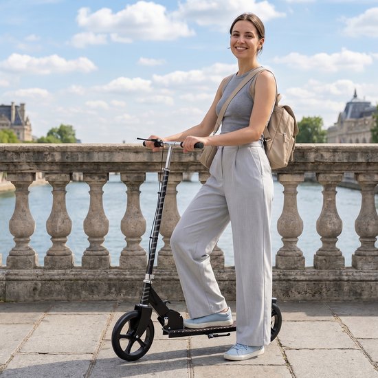 Vrouw in grijze outfit op zwarte step bij een brug in Parijs.