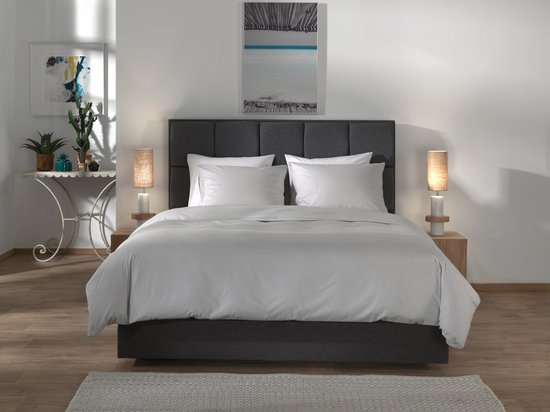 Een compleet opgemaakt bed met Vaporous Grey dekbedovertrek en witte kussens.