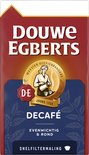 Rode verpakking van Douwe Egberts Decafé filterkoffie. Blauwe band met bloemmotief. Goudkleurig logo met vrouw en tekst 'Joure 1753'.