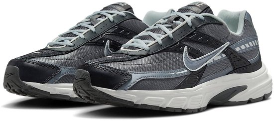Grijze Nike Initiator sneakers met zwarte en zilveren accenten.