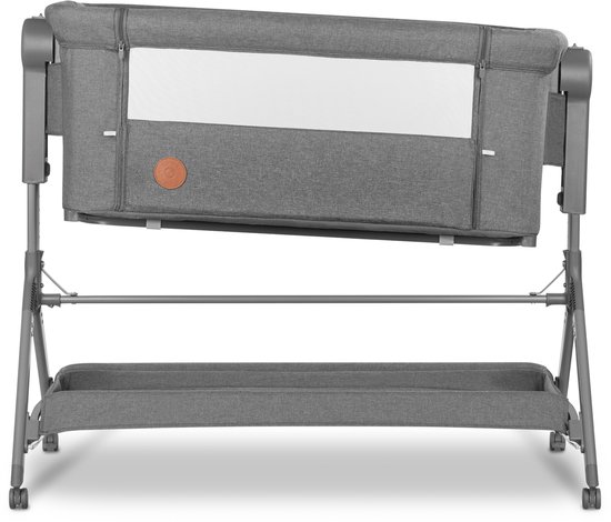 Grijze co-sleeper met een gestoffeerd frame, een verstelbaar matras en wieltjes aan de basis.