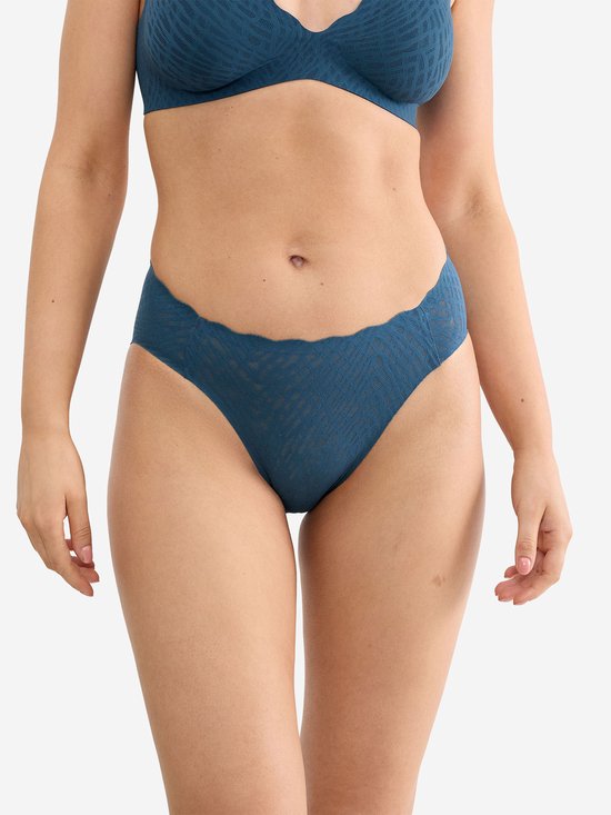 Model draagt donkerblauwe slip met golfvormige rand en visgraatpatroon.