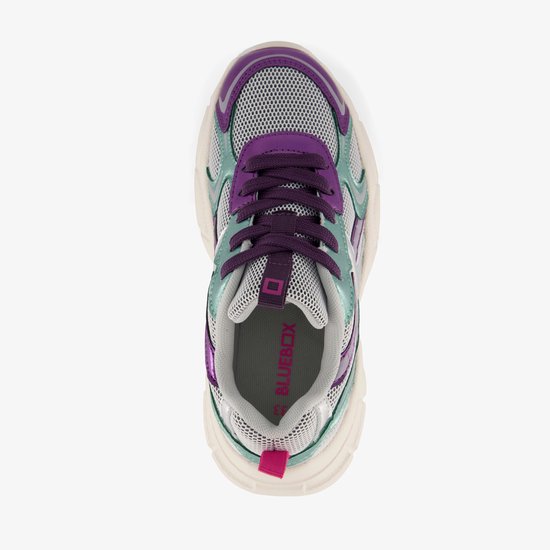 Blauwe dad sneakers van bovenaf gezien, met paarse en mintgroene details en een witte zool.