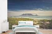 Behang - Fotobehang wolken boven de zee en de Tafelberg in Zuid-Afrika - Breedte 420 cm x hoogte 280 cm