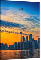 Vliegtuig passeert skyline van Toronto bij zonsongergang - Foto op Canvas - 30 x 40 cm
