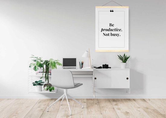 Werkplek met een bureau en een posterhanger met de inspirerende tekst 'Be productive. Not busy.'. Houten latten en ophangkoord.