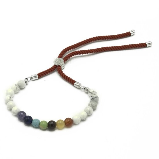 Armband met zeven chakra kralen, witte howliet kralen en bruin koord sluiting met zilveren details, op witte achtergrond.