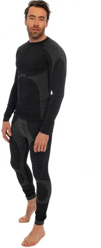 Man staat frontaal in een zwarte en grijs gemêleerde thermo set. Het shirt heeft een hoge kraag, de legging loopt tot de enkels. De set heeft contrasterende panelen.