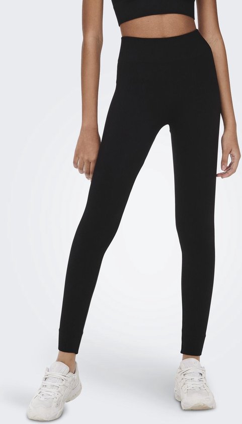 Model draagt een zwarte, nauwsluitende legging met hoge taille en ribbelstructuur.