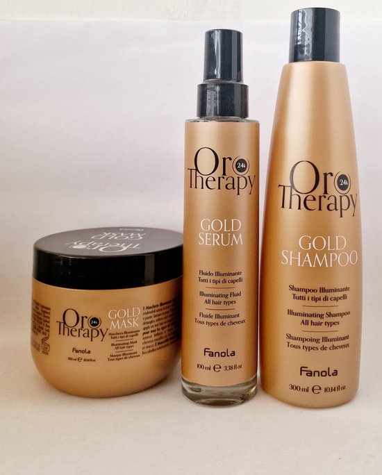 Drie gouden flessen met zwarte doppen: een pot masker (300ml), een spuitfles serum (100ml) en een shampoofles (300ml). Allemaal met het 'Oro Therapy'-logo.