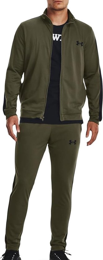 Man met een groen trainingspak van Under Armour. Zwarte strepen op de mouwen en zijkanten van de broek. Zwarte logo's.