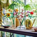Een boeket met LEGO bloemen, waaronder kersenbloesems, in verschillende vazen.