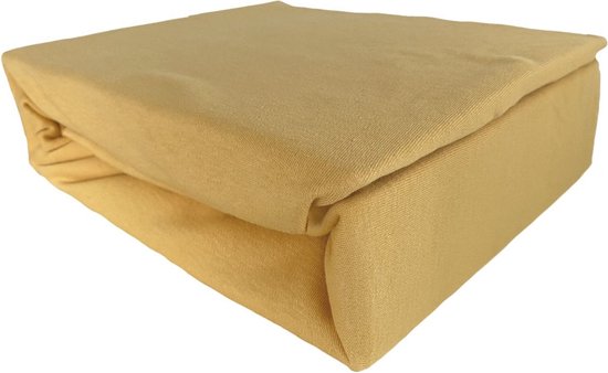 Okergeel jersey hoeslaken, opgevouwen, met een glanzende afwerking.