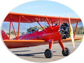 PVC Schuimplaat Ovaal - Rood Stuntvliegtuig Opstijgend vanuit Vliegbasis - 56x42 cm Foto op Ovaal (Met Ophangsysteem)