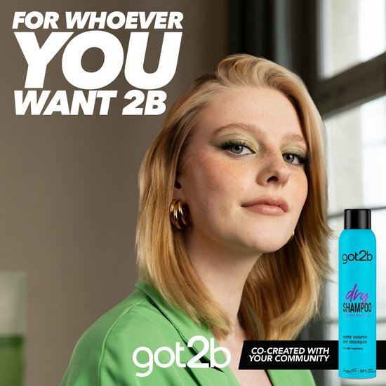 Une jeune femme avec du fard à paupières vert et des boucles d'oreilles dorées porte un blazer vert. À sa droite se trouve un flacon bleu de shampoing sec Got2b.