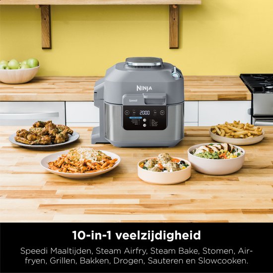 Grijze Ninja Speedi multicooker op aanrecht, omringd door diverse bereide gerechten. 10-in-1 veelzijdigheid.