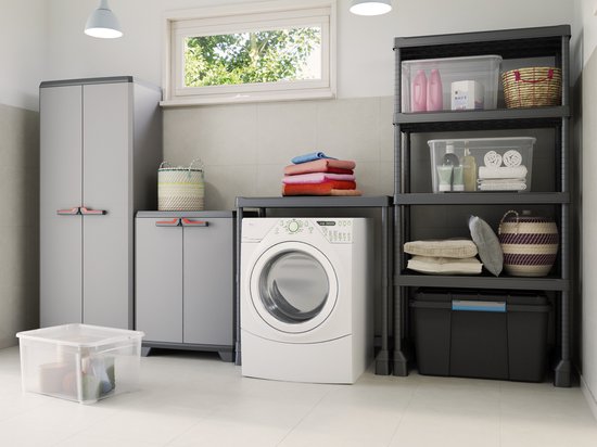 Grijze opbergkasten naast een wasmachine in een bijkeuken.
