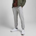 Man in een lichtgrijze joggingbroek, met een klein V-logo op de heup.