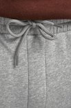 Sluit detail van de strik van het trekkoord van een lichtgrijze joggingbroek.