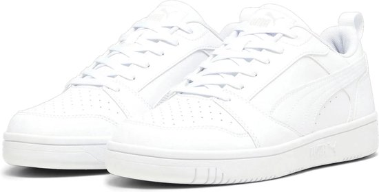 Een paar witte PUMA Rebound v6 Low sneakers, met perforaties op de neus en PUMA branding op de zool.