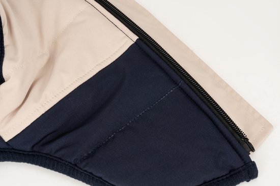 Gedetailleerd deel van een marineblauwe en beige hondentrui met rits en naden.