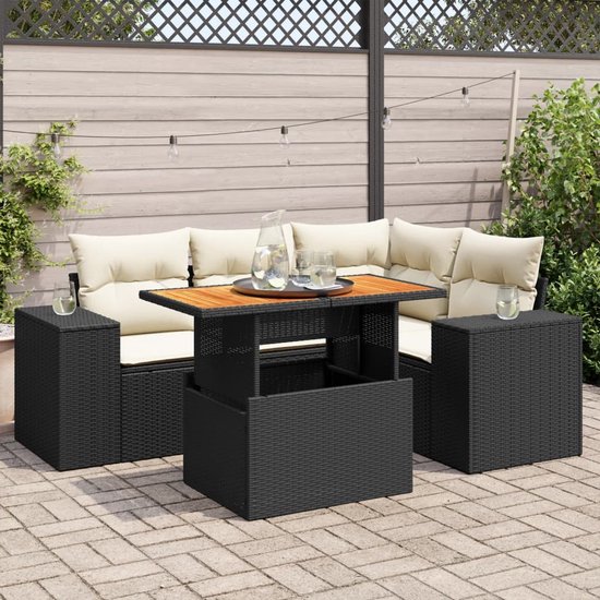 Zwarte loungeset met crèmekleurige kussens en verstelbare houten tafel op terras.