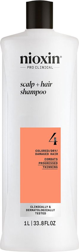 Een grote witte fles Nioxin System 4 shampoo met een oranje label voor gekleurd, droog en beschadigd haar.