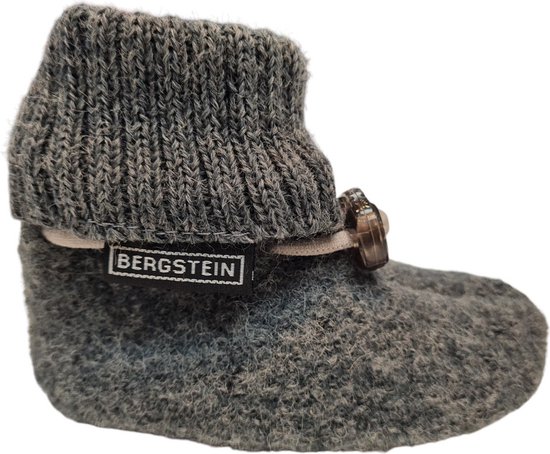 Grijze wollen babyslof met gebreide boord en decoratieve knoop. Het "BERGSTEIN" logo is zichtbaar.