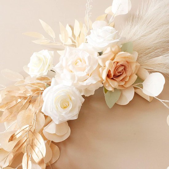 Boeket met crèmekleurige, witte en roze rozen, gouden bladeren en pampasgras, op zandkleurige achtergrond.