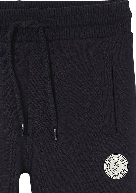 Detail van donkerblauwe joggingbroek met trekkoord, steekzak en patch met skateboarder.