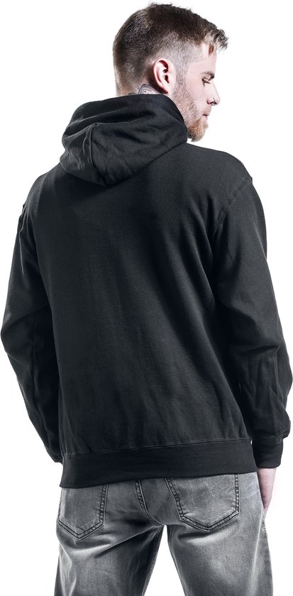 Man van achteren gezien, draagt een zwarte hoodie met capuchon en grijze jeans.