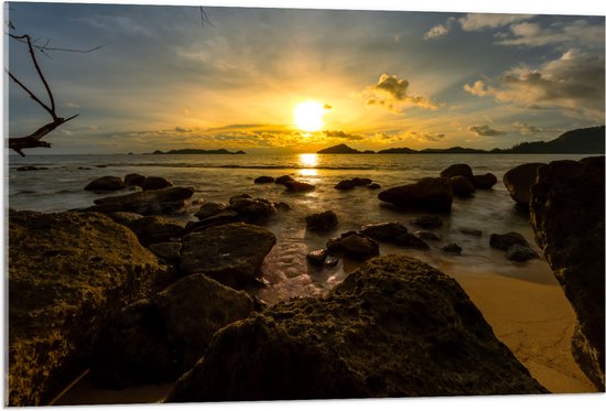 Acrylglas - Zon verdwijnend achter Wolken boven de Zee vol Rotsen - 105x70 cm Foto op Acrylglas (Met Ophangsysteem)
