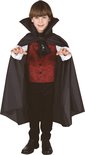 Jongen in vampierkostuum met zwarte cape, rood vest met spinnenwebben, wit shirt en zwarte broek.