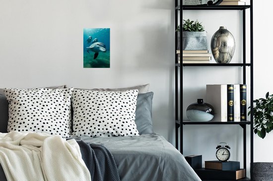 Trois dauphins nagent sous l'eau dans une eau bleue avec des rayons de soleil, accrochés à un mur de chambre.