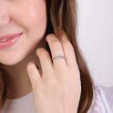 Vrouw draagt een zilverkleurige ring met zirkonia aan haar rechterhand.
