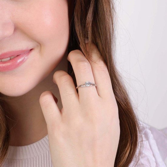 Vrouw draagt een zilverkleurige ring met zirkonia aan haar rechterhand.
